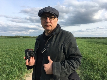 A photo of Rawi Hage holding a camera